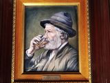 painting of an old man drinking a glass of wine in a wooden frame