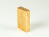 a gold lighter sitting on top of a white surface