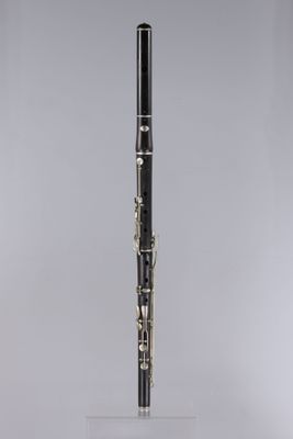 a black and gold clarinet on a clear acrylic stand