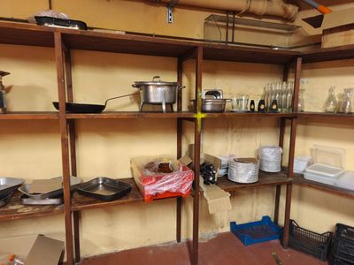 des étagères sur lesquelles sont posées des casseroles et des poêles, dans une petite pièce