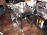 a stainless steel table with a bowl on it in a kitchen