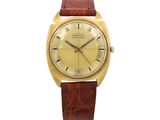 a gold plated wrist watch with brown leather strap