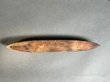 an old wooden knife on a gray surface with a black handle