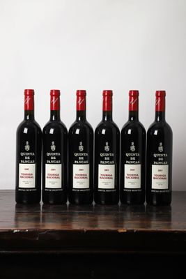 six bouteilles de vin rouge alignées sur une table en bois