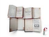 several open books sitting on top of each other on a white surface