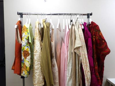 a lot of clothes hanging on a rack in a room