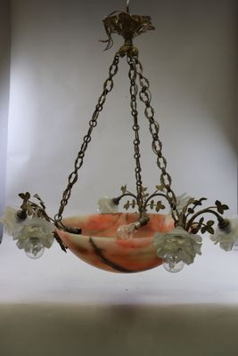 un bol en verre avec des fleurs suspendues à une chaîne