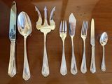 a lot of silverware on a table with a knife and fork