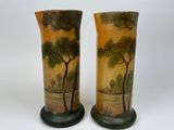 two vases with trees painted on them sitting on a table