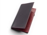 un portefeuille noir et rouge posé sur une surface blanche