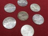 six different coins on a red cloth with a red background