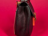 a close up of a black purse on a red background