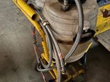 a yellow cart with a hose attached to it in a garage
