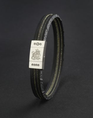 a close up of a black leather bracelet with a silver clasp