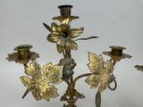 a candle holder that has a bunch of flowers on it