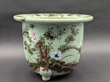 une image représentant un vase vert orné de fleurs et d'oiseaux