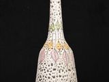 a white vase with a pink and yellow design on it