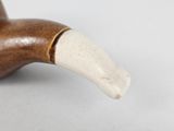 a wooden pipe with a white handle on a table