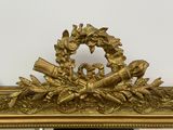 a gold clock with a wreath on top of it