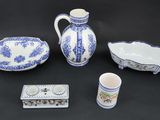 four pieces of blue and white pottery on a black background