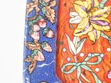 an orange and blue plate with a floral design on it