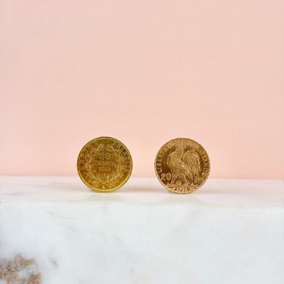 a pair of gold coins sitting on top of a marble counter