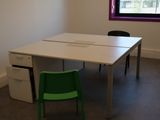 une table blanche avec une chaise verte devant