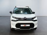 the front view of a white citrole parked in a showroom