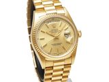 an image of a gold rolex watch on display on a stand