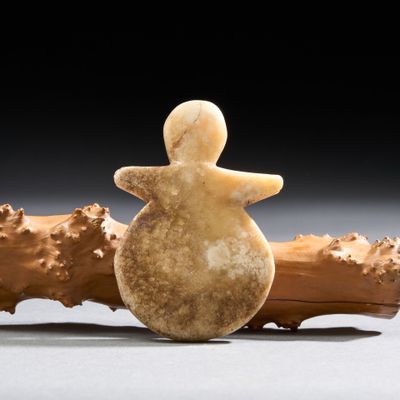 figurine représentant une femme assise sur un tronc d'arbre