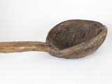 une cuillère en bois avec un manche en bois posée sur une surface blanche