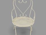 a white iron chair with a heart shaped back and arms