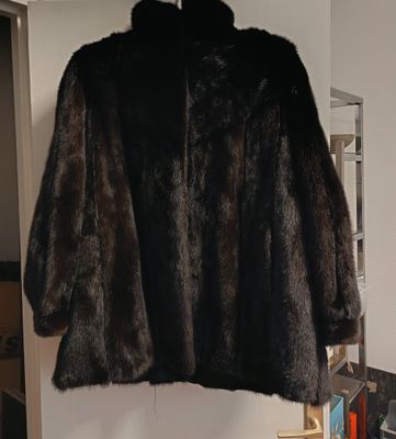 un manteau de fourrure suspendu à un porte-manteau dans une pièce