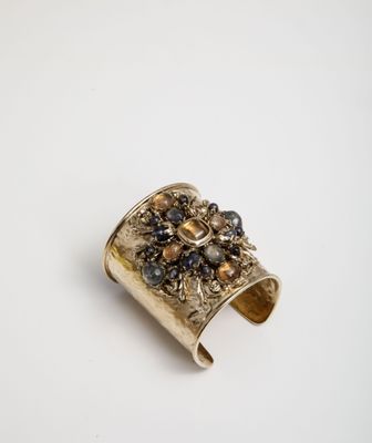 a close up of a gold ring with a flower design on it