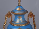 a blue vase with gold decoration on it on a table