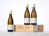 three bottles of wine sit in front of a wooden box