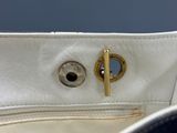 a close up of a white purse with a gold handle