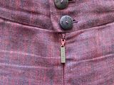 the back of a pink skirt with buttons on the side