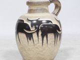 un vase noir et blanc orné de deux éléphants