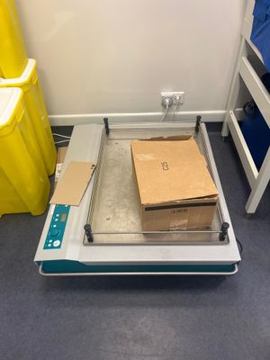boxes are stacked on a scale in a room with yellow bins and blue bins