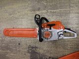 an image of a chainsaw on the ground next to a tool