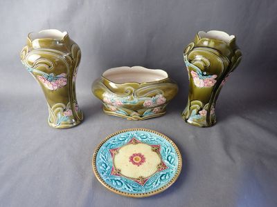 three vases and a plate sitting on a table