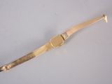 a close up of a gold bracelet on a white surface