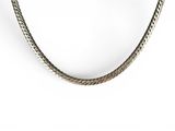 a close up of a necklace on a white surface with a white background