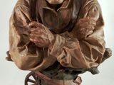 statue of an old man with a hat on his head and hands folded over his chest