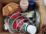 une boîte en carton remplie d'objets divers, posée par terre