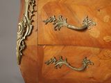 a wooden chest of drawers with a marble top