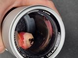 a person holding a camera lens with a pencil in it