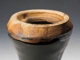 a black and brown vase sitting on a table