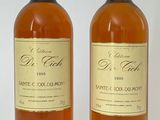 deux bouteilles de vin posées l'une à côté de l'autre sur une surface blanche